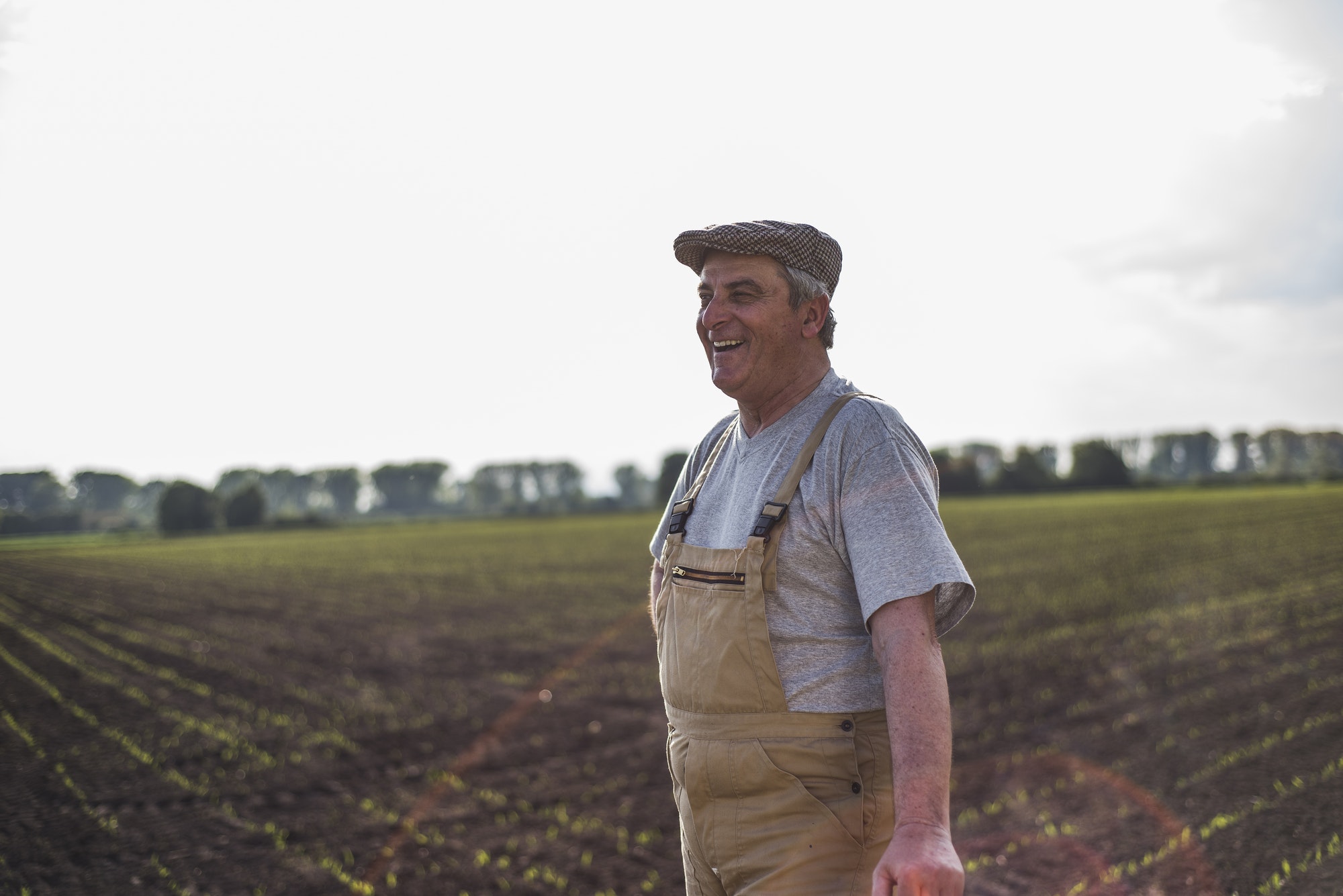 Smiling farmer standing at a field